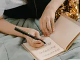 Pige skriver noder ned i hæfte